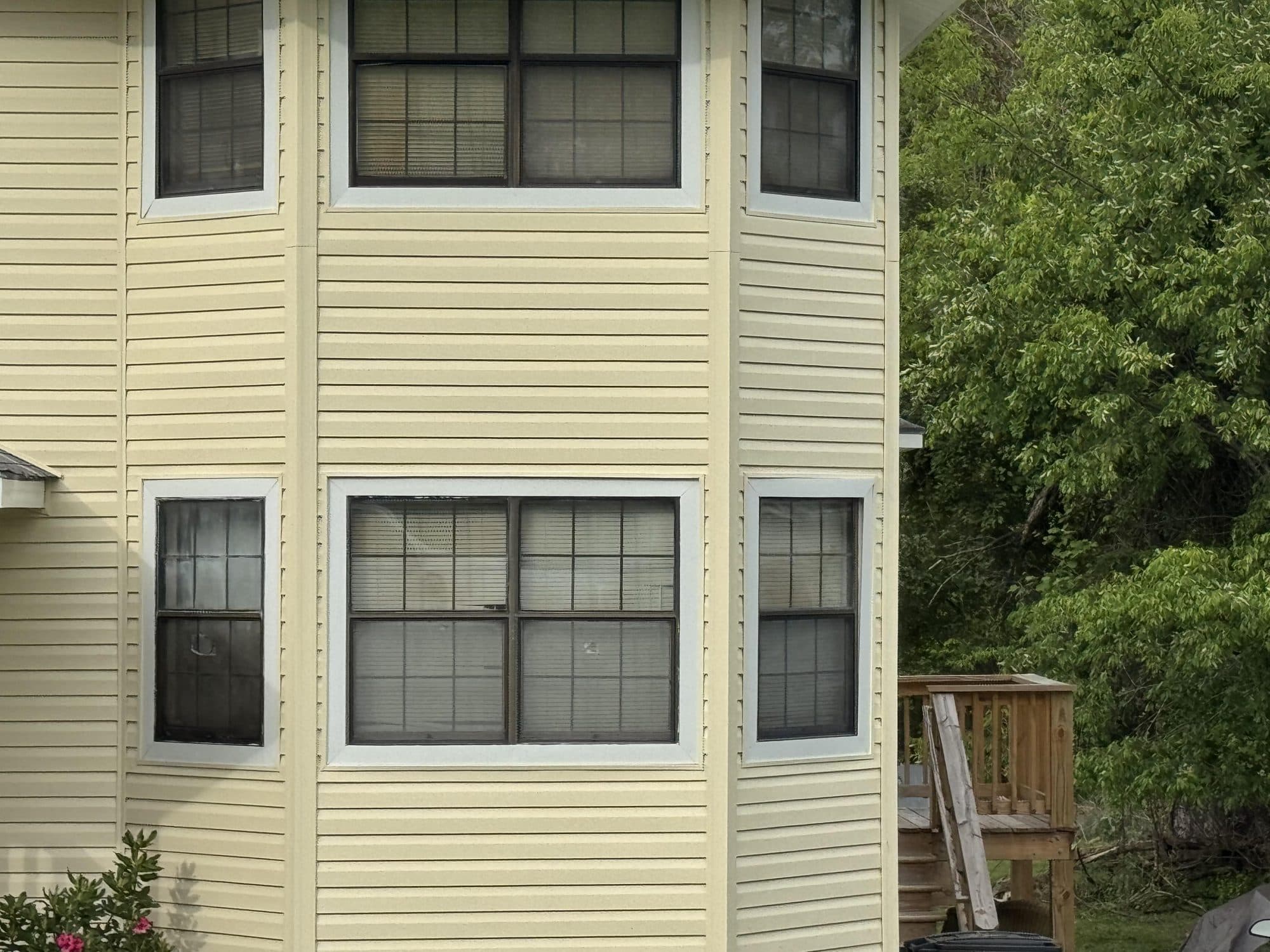 Cream vinyl siding installed on a home with a bay window